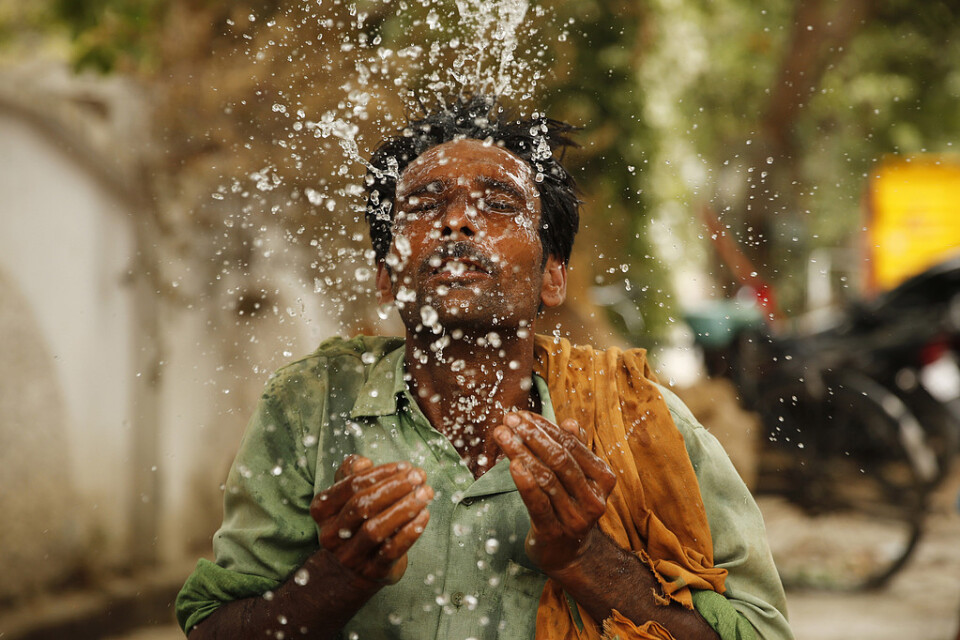 En arbetare kyler av sig i indiska Prayagraj. I framtiden kommer högre temperaturer leda till lägre produktivitet, skriver ILO i en ny rapport. Arkivbild.