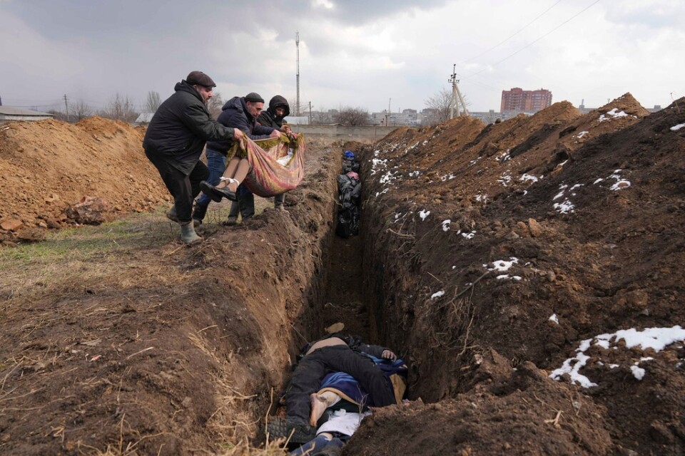 Kroppar kastas ned i en massgrav i utkanten av Mariupol, den 9 mars förra året. Ryssland utsatte staden för hård beskjutning och det blev svårt för civilbefolkningen att begrava sina anhöriga. Arkivbild.