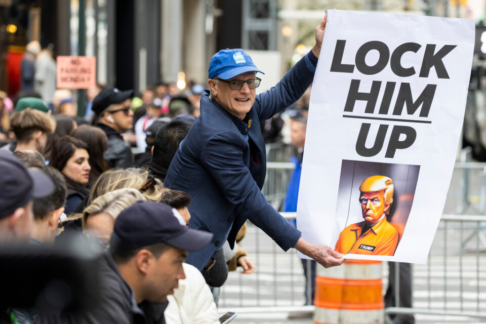 En demonstrant håller en skylt utanför Trump Tower i New York på måndagen.