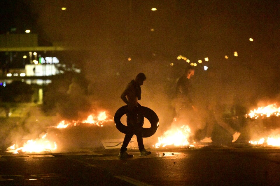 Demonstranter bränner däck i samband med upploppet i Malmö i slutet av augusti.