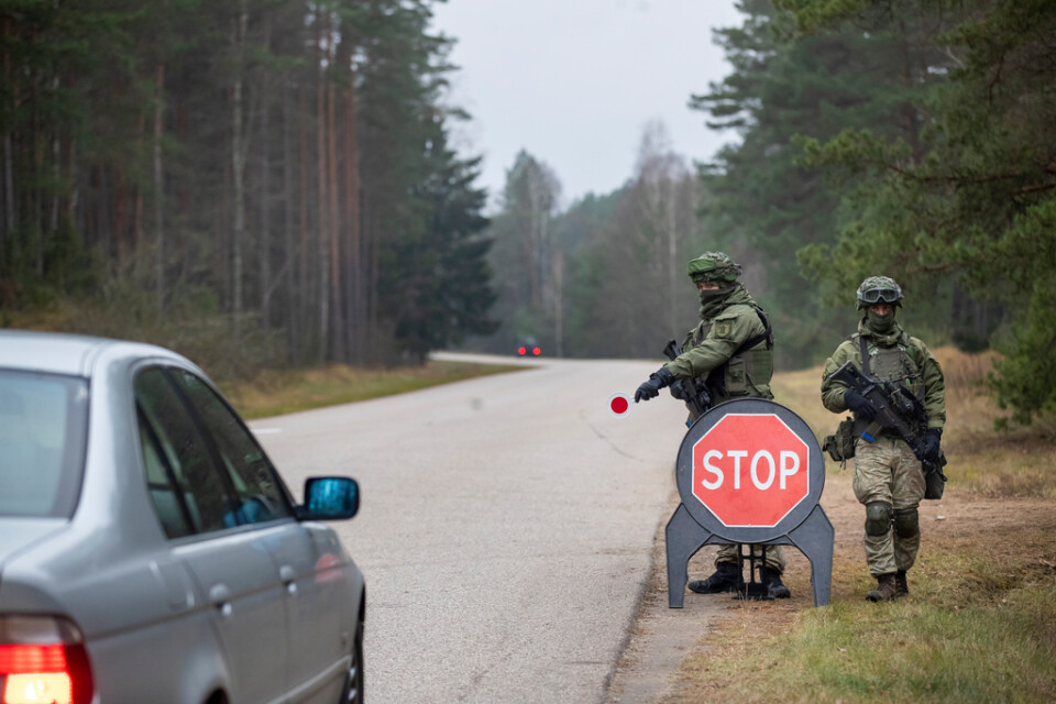 Litauisk militär kontrollerar bilar på en väg nära gränsen till Belarus i byn Jaskonys.
