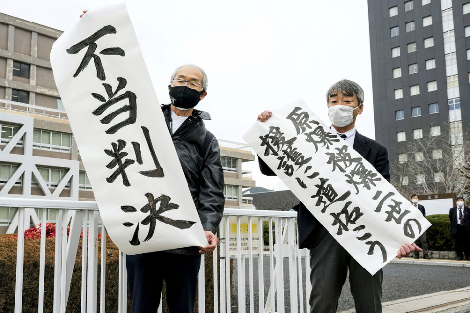 Katsuhiro Hirano och hans advokat protesterar efter domen i Hiroshima.