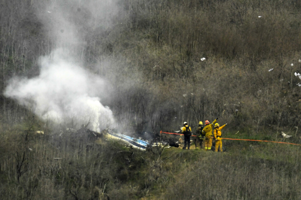Brandmän jobbar vid platsen där Kobe Bryants helikopter kraschade.