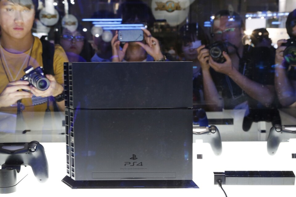 Människor tar bilder på konsolen Playstation 4 vid Tokyo Game Show 2013. Jättarna Sony och Microsoft får i år visa upp sina kommande tv-spelskonsoler på andra sätt.