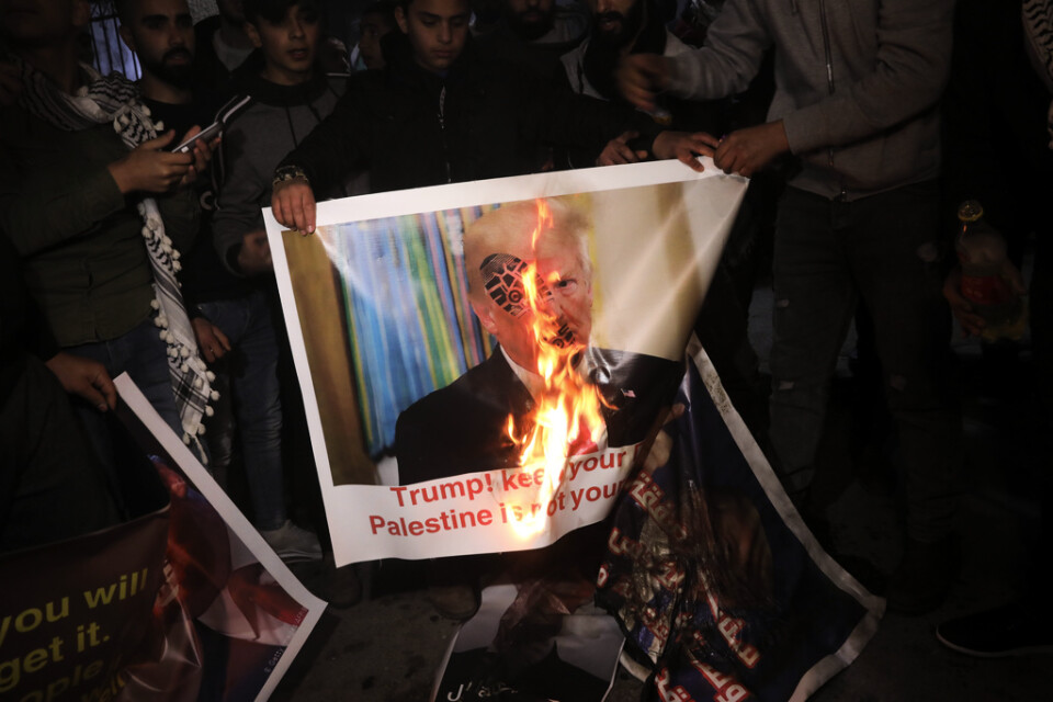 Palestinier bränner en affisch med Trumps bild under en protest nära Betlehem på tisdagskvällen. 