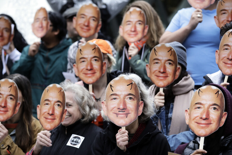 Demonstranter med bilder på Amazons vd Jeff Bezos under en protest i Seattle 2018 mot användandet av företagets ansiktsigenkänningsteknik "Rekognition".