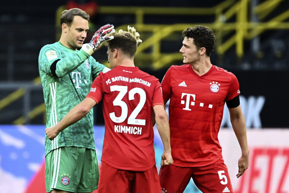 Bayern Münchens Joshua Kimmich, mitten, kramas om efter att lobbat in segermålet borta mot Dortmund.