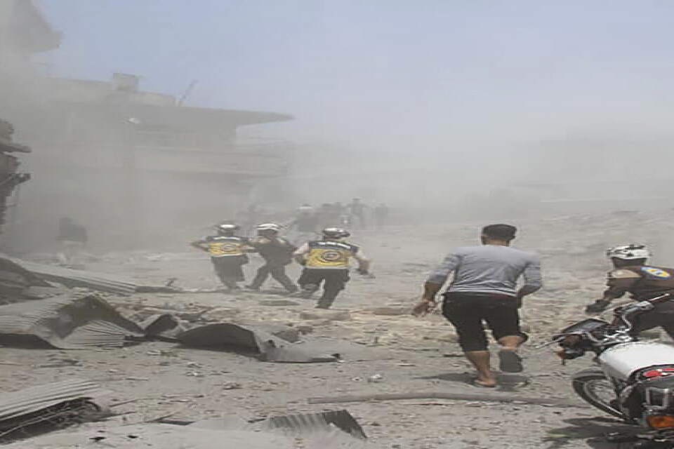Räddningsarbetare röjer upp efter ett flyganfall mot Jisr al-Shughur utanför Idlib tidigare denna månad. Arkivbild.