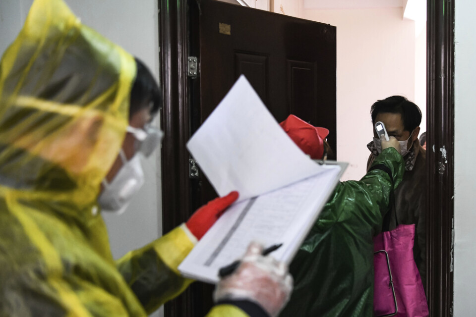 Invånare i Wuhan kontrolleras för feber i en dörrknackningskampanj. Bild från tidigare i veckan.