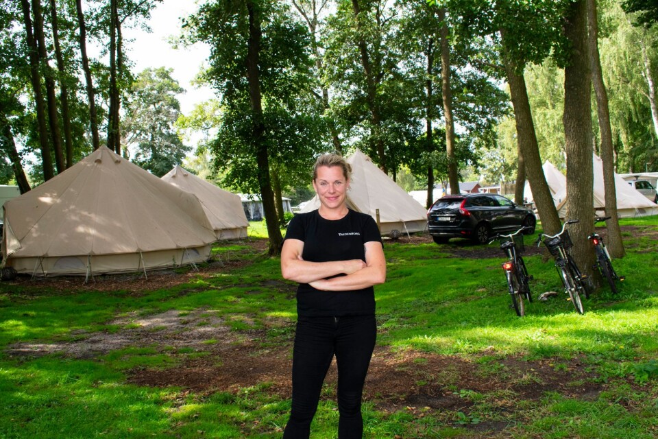 Jenny Grönlund, som driver Tredenborgs camping, står framför flera av glampingtälten.