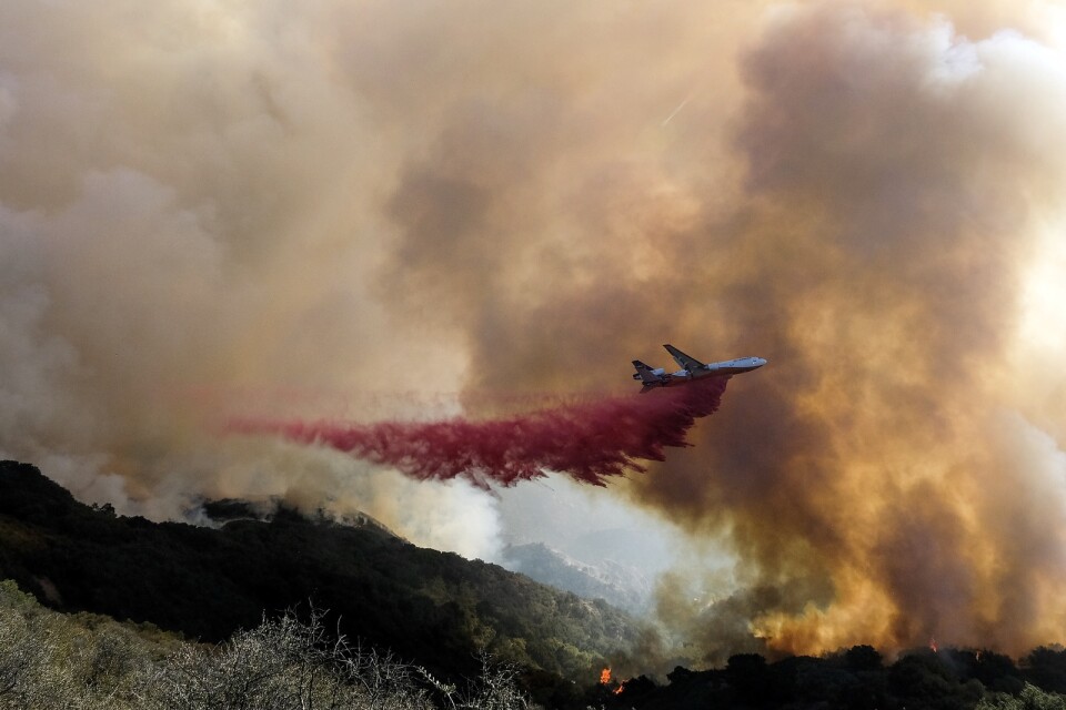 Ett brandbekämpningsflyg släpper sin last över Alisalbranden i Kalifornien