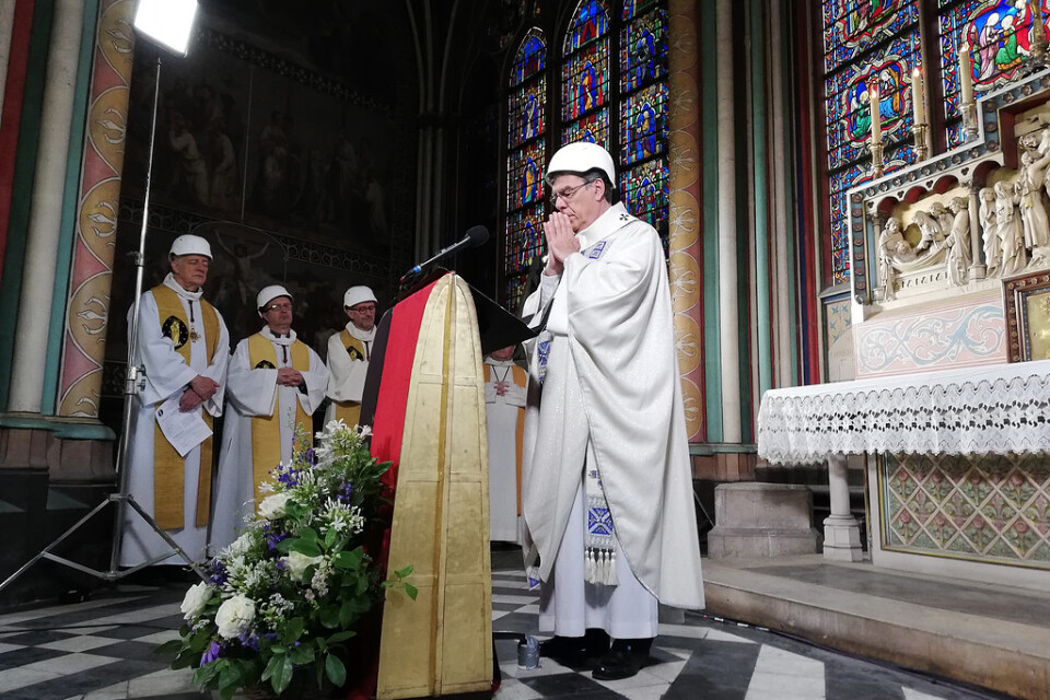 Paris ärkebiskop Michel Aupetit, klädd i hjälm, leder den första mässan efter branden i Notre Dame.