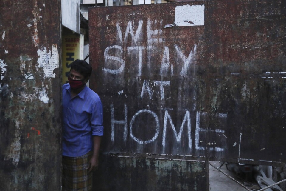"Vi stannar hemma" har sprejats på en port i Hyderabad. Men Indien gör sig redo att slopa ännu fler virusrelaterade restriktioner. Bild från april.