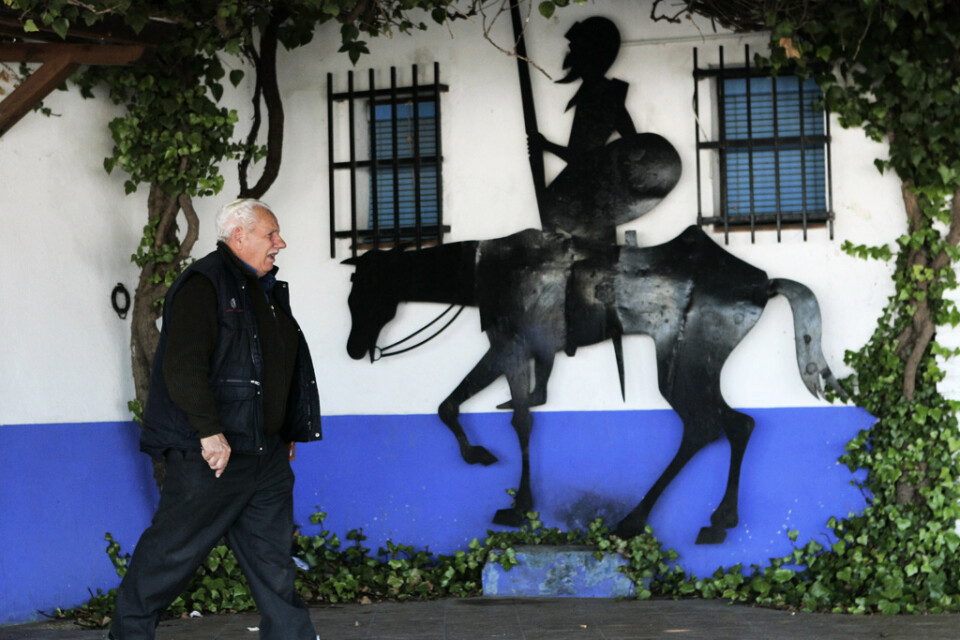 En man går förbi en bild av "Don Quijote" i La Mancha, Spanien. Arkivbild.