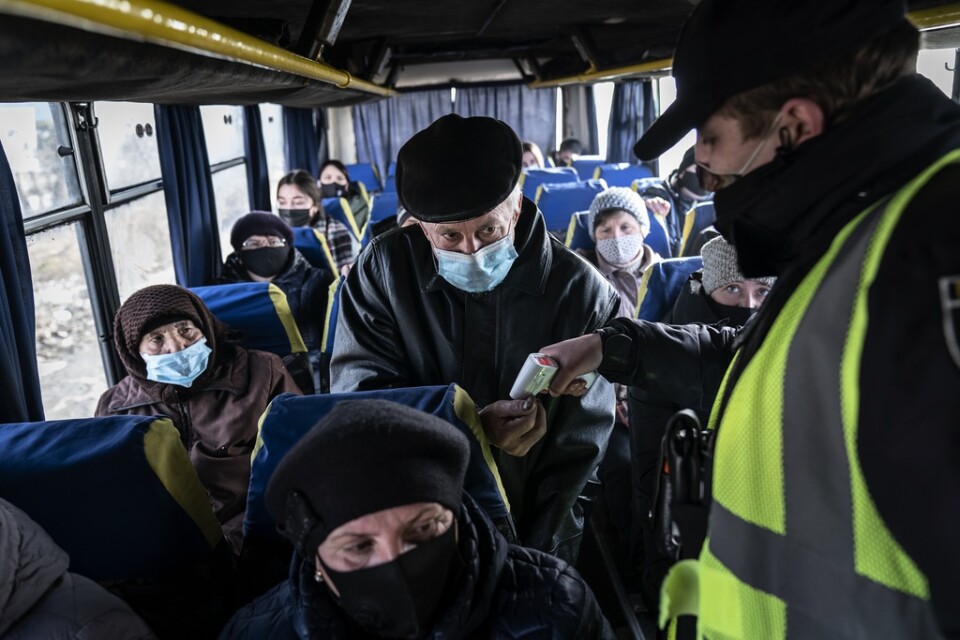En polis mäter temperaturen på passagerare på bussen i närheten av i Ivano-Frankivsk i Ukraina. Arkivbild.