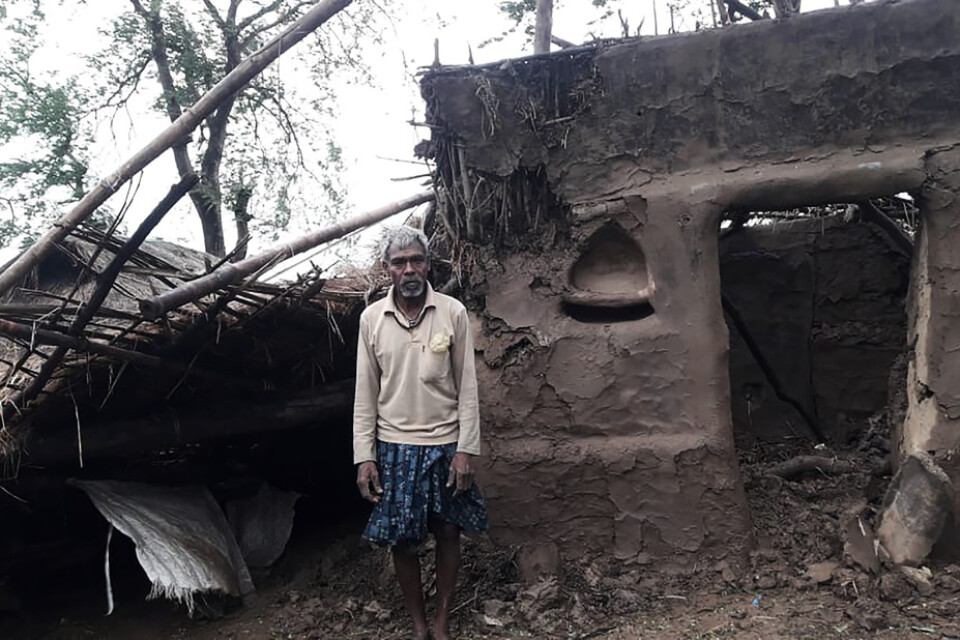 En bybo framför sitt hus som skadats av cyklonen Amphans framfart i distriktet Bhadrak i delstaten Odisha i Indien.
