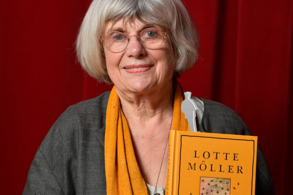 Lotte Möller med boken "Bin och människor. Om bin och biskötare i religionen, revolutionen och evolutionen samt många andra bisaker".