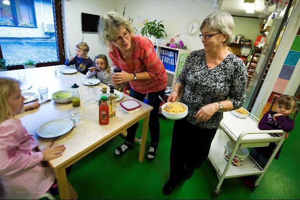 Förskollärarna Karin Vilör och Inger Nilsson dukar fram dagens lunch – kasslergratäng.