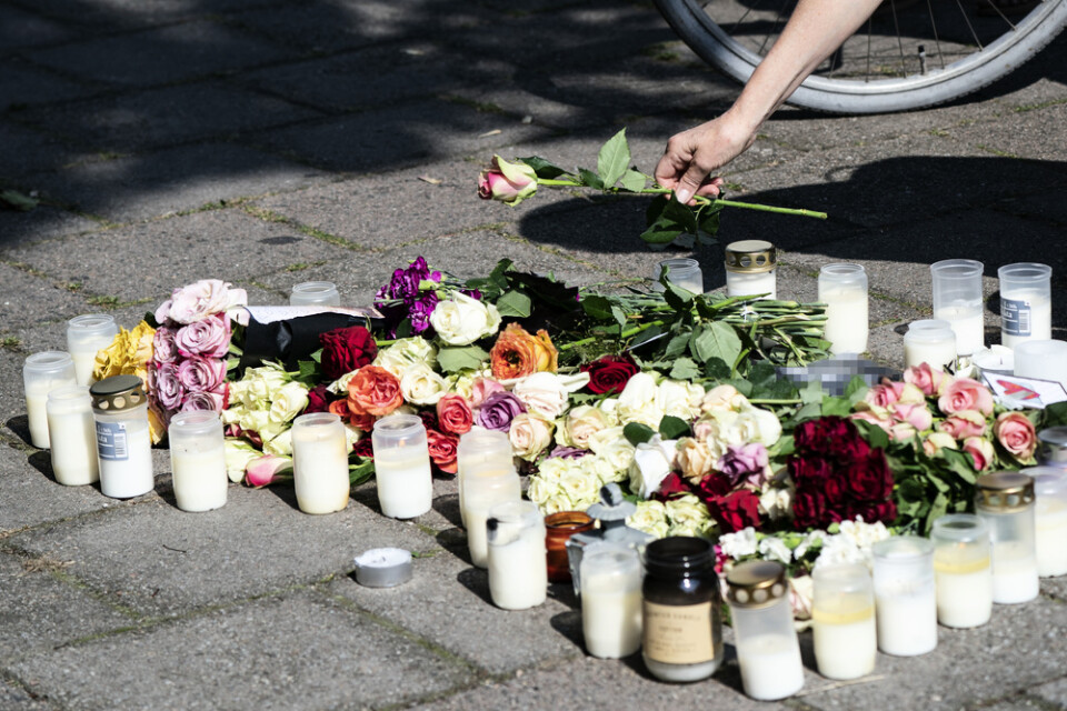 En kvinna lägger ner en ros vid minnesplatsen på Sergels väg i stadsdelen Ribersborg i Malmö där en 30-årig kvinna skjutits till döds föregående dag. Arkivbild.