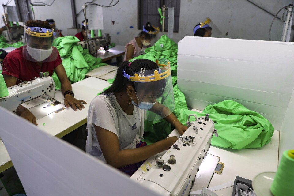 Textilarbetare i Rangoon, Myanmar, en av de länder med stor textilindustri. Arkivbild.
