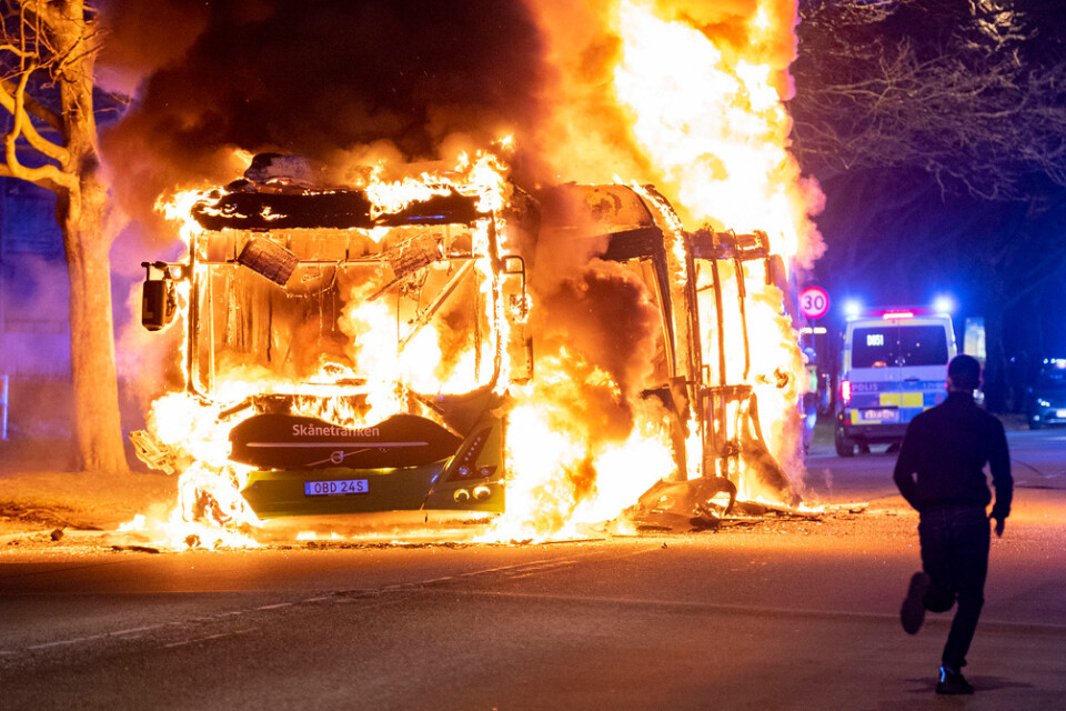 Kravallpolis på plats då en stadsbuss brinner i Rosengård i Malmö natten till den 17 april förra året. Arkivbild.