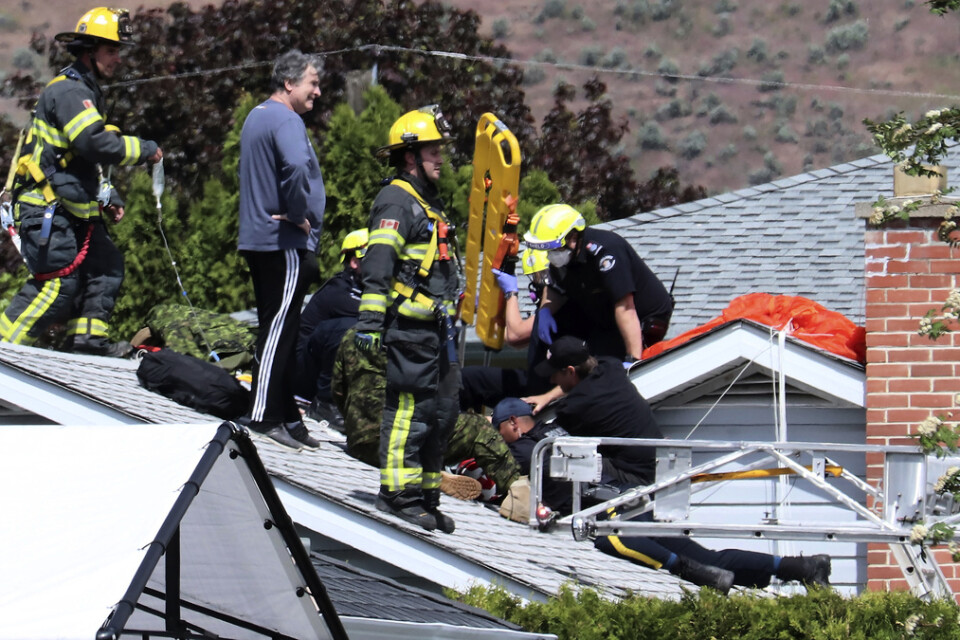 Räddningspersonal tar hand om en skadad person på ett tak i Kamloops i Kanada.