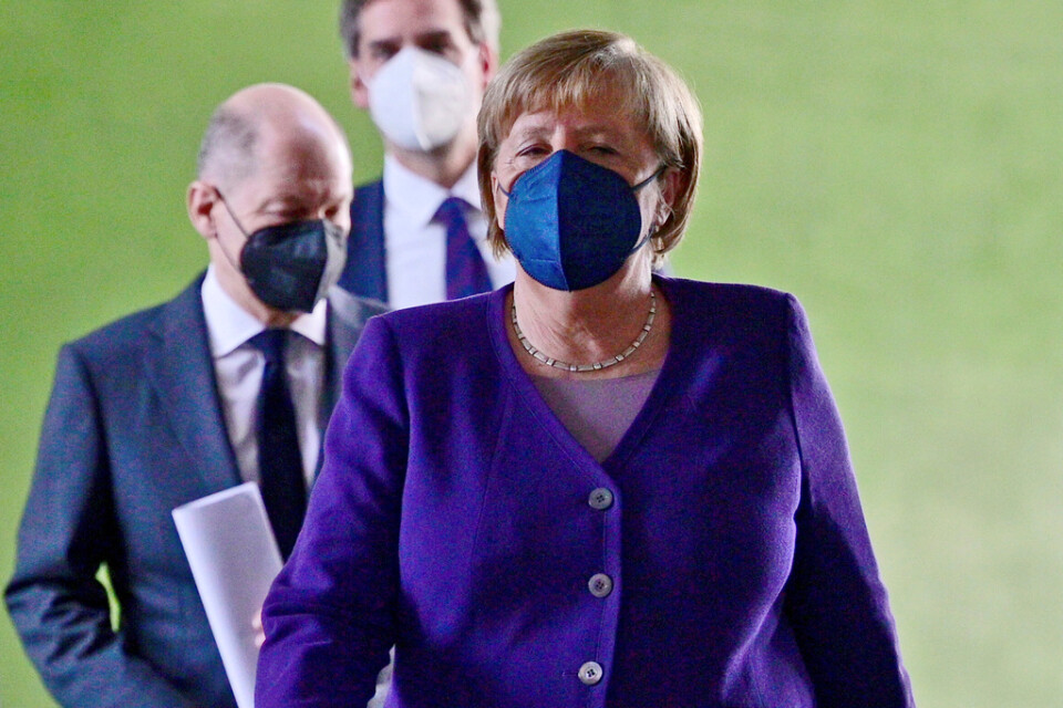 Tysklands avgående förbundskansler Angela Merkel, med tillträdande förbundskansler Olaf Scholz strax bakom, har i samråd med förbundsländernas ledare beslutat att skärpa kraven om vaccinering.