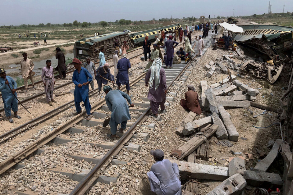 Räddningsarbetare under måndagen, inbegripna i reparationsarbete av rälsen där söndagens tågolycka skedde i Sindprovinsen i södra Pakistan.