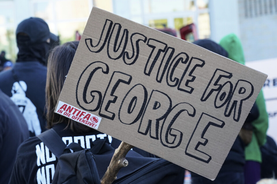 Ett plakat med texten "rättvisa för George" med ett Antifa-klistermärke i hörnet. Arkivbild.