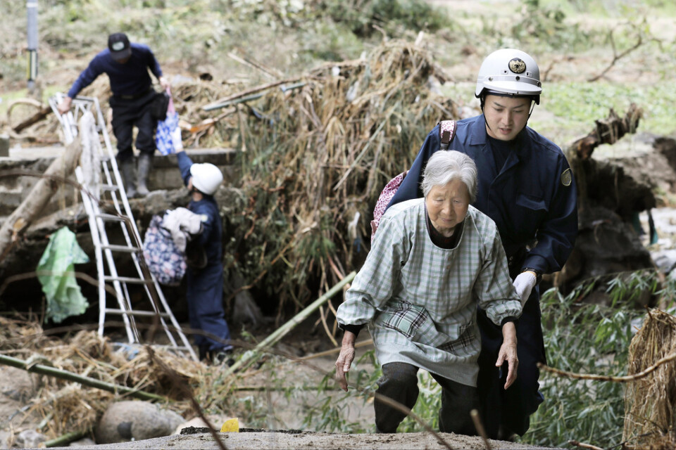Räddningsarbetare hjälper invånare i Fukushima.