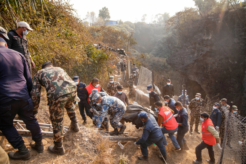 Räddningstjänsten som arbetar med att få ut alla ur passagerarplanet som kraschat i staden Pokhara i Nepal.