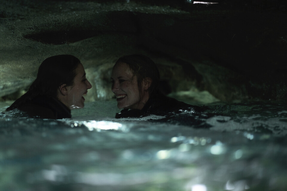 Två systrar (Madeleine Martin och Moa Gammel Ginsburg) gör sitt traditionsenliga vinterdyk, när de drabbas av ett stenras, i thrillern ”Breaking surface”. Pressbild.