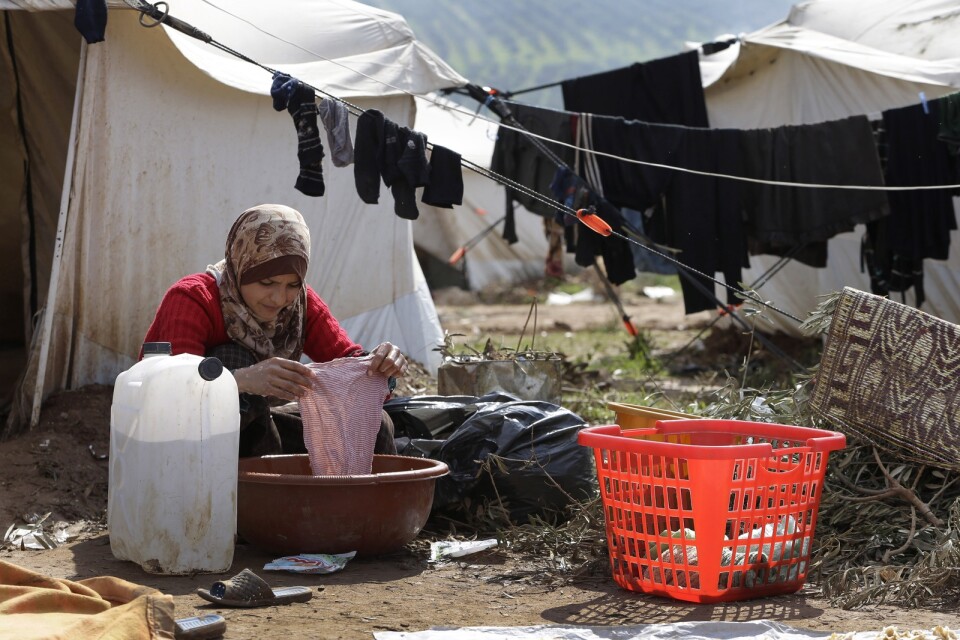 En kvinna tvättar kläder utanför sitt tält i ett flyktingläger i staden Atmeh i norra Syrien. Om coronaviruset får fäste i området vore det förödande, varnar hjälporganisationer. Arkivbild.