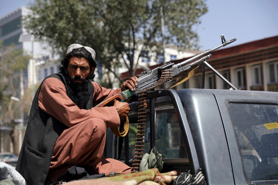 En stridande taliban håller vakt vid huvudentrén till presidentpalatset i Afghanistans huvudstad Kabul.
