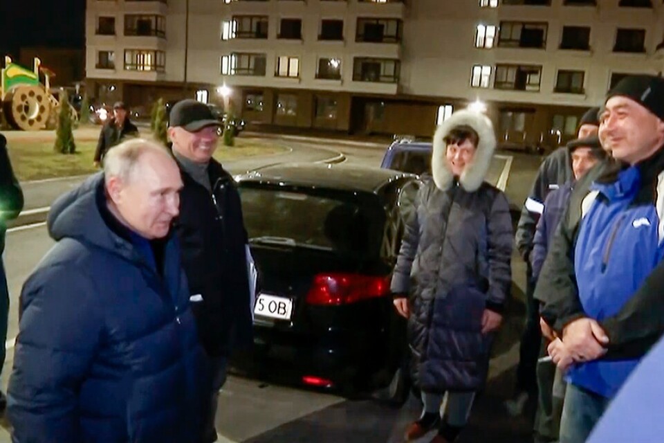 Rysslands president Vladimir Putin i samspråk med en grupp personer som beskrivs som lokalinvånare i Mariupol. Bilden är distribuerad av Kreml.