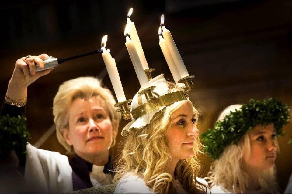 Kyrkoherde Louise Nyman tände ljusen i Josefine Darins krona under kröningen.
