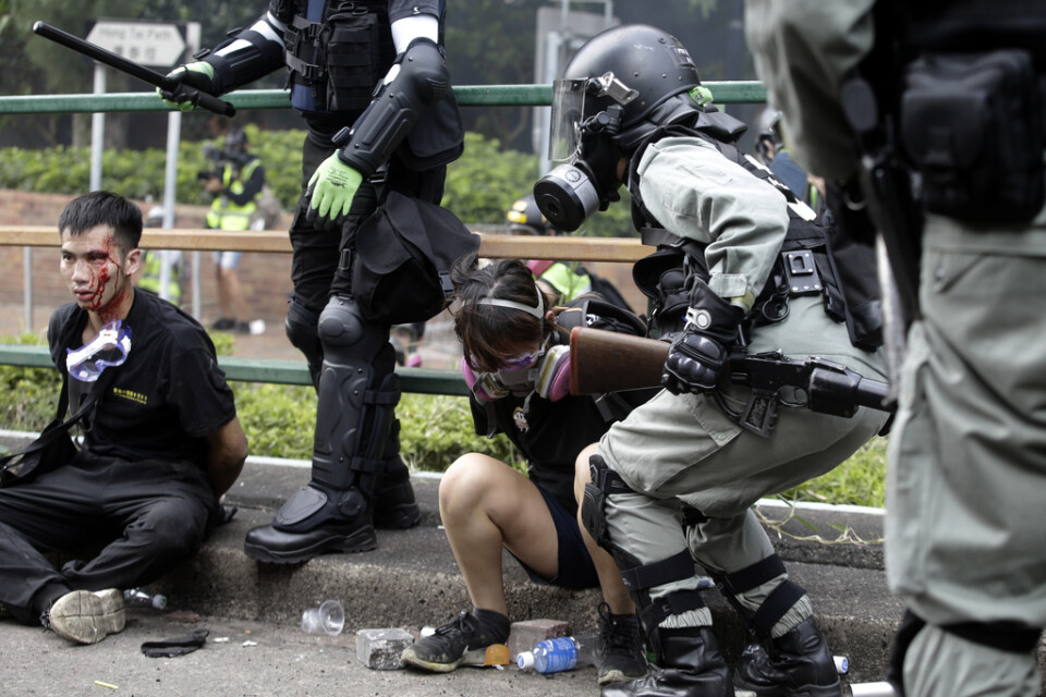 Poliser med två gripna demonstranter utanför Hong Kong Polytechnic University.