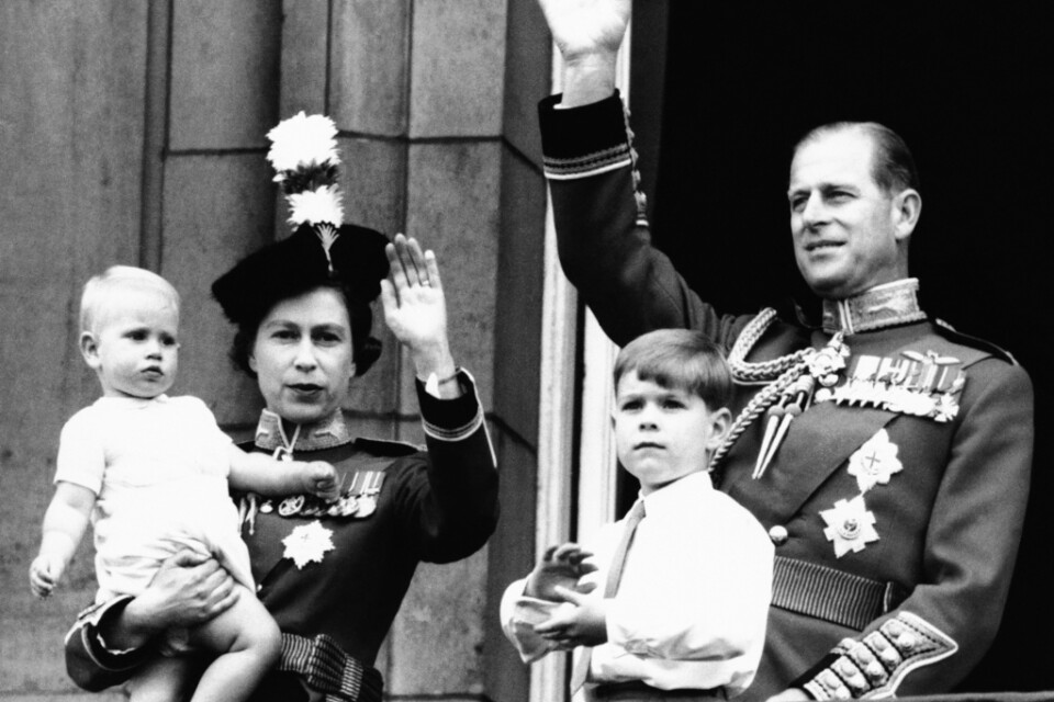 Drottningparet Elizabeth och Philip vinkar från Buckingham Palace i juni 1965, tillsammans med sönerna Edward och Andrew.