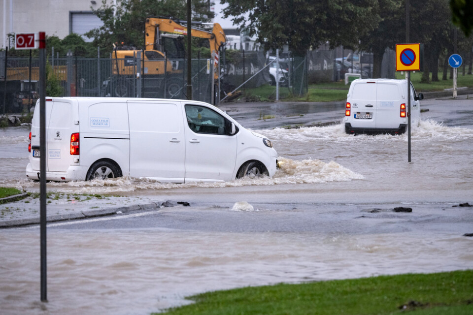 Bilar försöker ta sig genom en översvämmad rondell i Arlöv vid den avstängda, översvämmade Västkustvägen utanför Malmö.