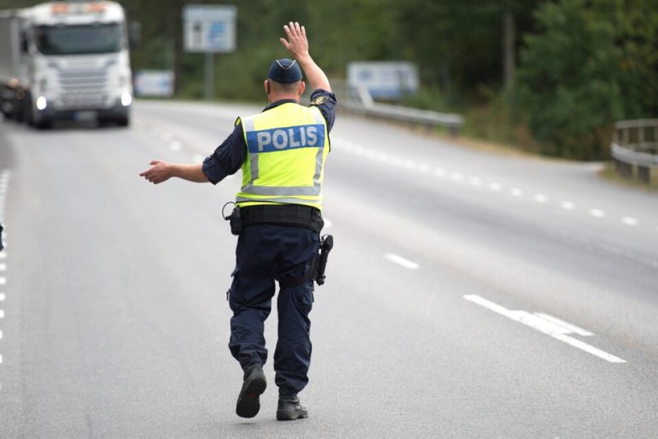 En trafikpolis vinkar in en lastbil i Karlshamn.