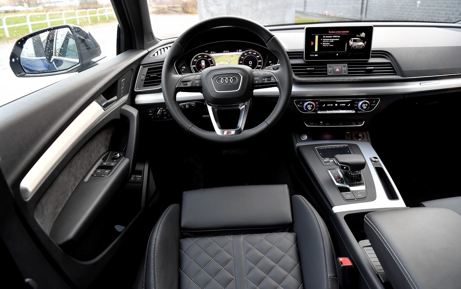 En lite spretig förarmiljö, sedan Q5 lanserades har Audi hunnit introducera en ny inredningsdesign. Men det mesta funkar bra och det är hög nivå på menysystem och ergonomi.