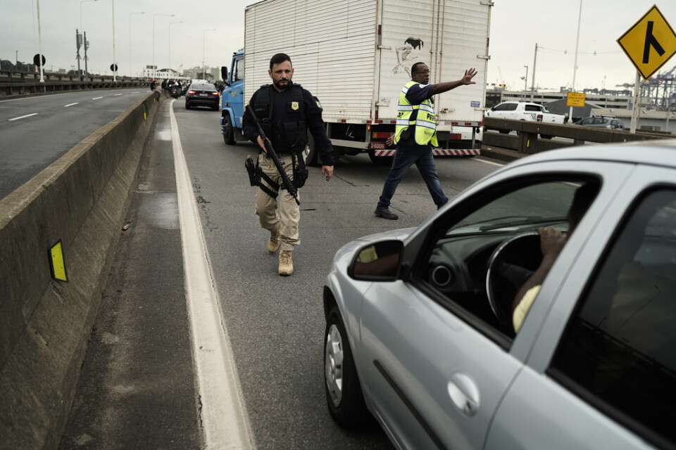 En beväpnad polis stoppar trafik från att köra upp på en bro som förbinder Rio de Janeiro med grannstaden Niteroi. På bron utspelade sig ett gisslandrama under tisdagen.
