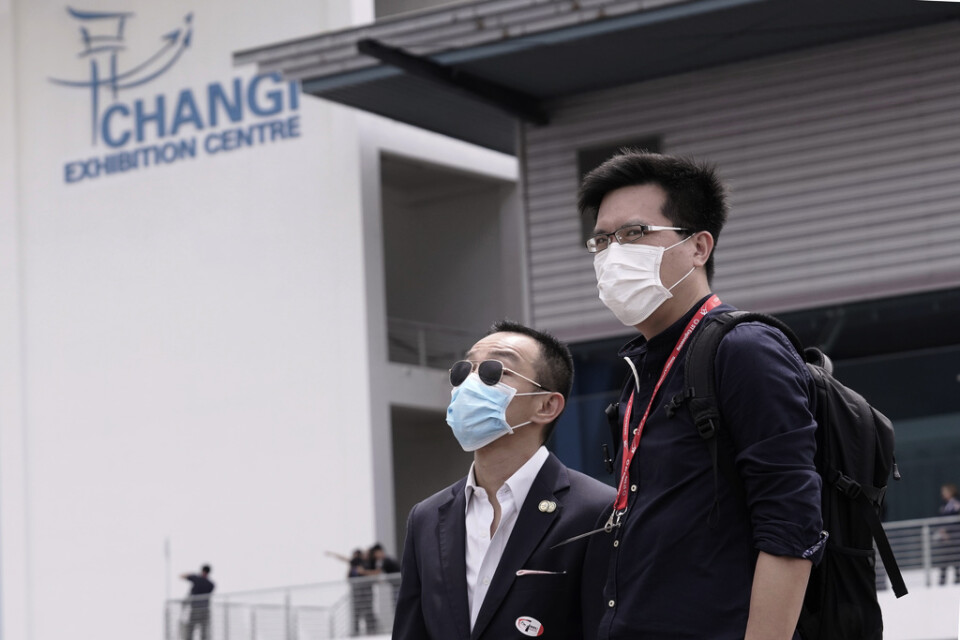 Besökare på Singapore Airshow har på sig munskydd mot viruset i februari 2020.