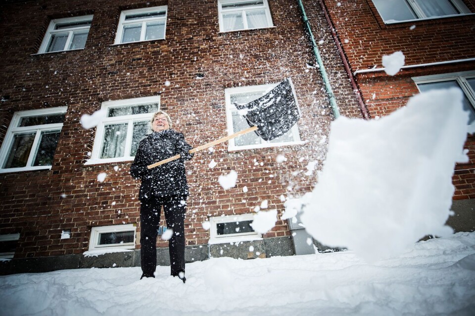 Kjerstin Olsson skottar snö utanför sin fastighet.