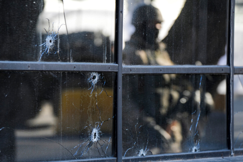 Skotthål i fönstret till en butik i Almaty i Khazakstan. I reflektionen syns en kazakstansk soldat som håller vakt. Bilden är från i fredags.