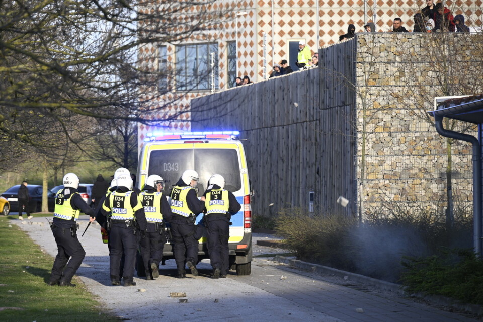 16 april förra året: Motdemonstranter kastar sten mot kravallutrustad polis och en polisbuss vid Skånegården i Malmö där Rasmus Paludan, partiledare för det danska högerextrema partiet Stram kurs, höll en manifestation.
