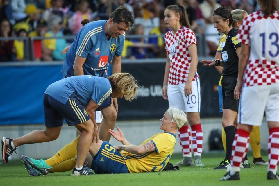 Sveriges Nilla Fischer får hjälp med en skada under mötet med Kroatien.