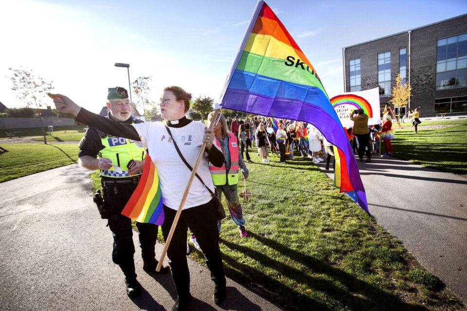 Kommunpolis Mikael Svensson och prästen Lotta Rosman Nissen med Prideflaggan i högsta hugg under förra årets parad.