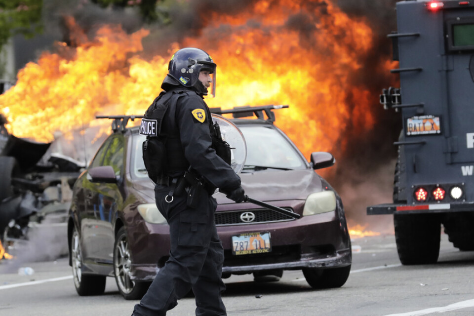 En polis bevakar en brinnande bil i Salt Lake City på lördagen.