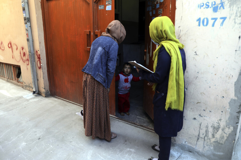 Hälsovårdsarbetare går från dörr till dörr för att erbjuda poliovaccin under en vaccineringskampanj i Afghanistans huvudstad Kabul. Under tisdagen sköts tre kvinnor som arbetade med poliovaccinering i östra Afghanistan. Arkivbild.